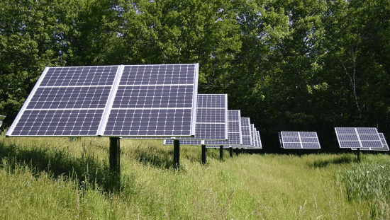 Solceller monterade på marken nära lantbruk